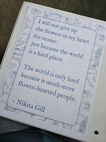 A quote in a binder reads: "I will not give up the flowers in my heart for stones just because the world is a hard place. The world is only hard because it needs more flower-hearted people. - Nikita Gill